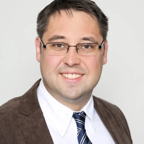 a man wearing glasses and a suit